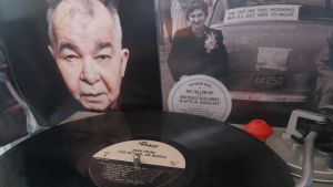 John Prine på vinyl, The Tree of Forgiveness och For Better, or Worse Skivspelare med vinyl på tallriken i bakgrunden två konvolut