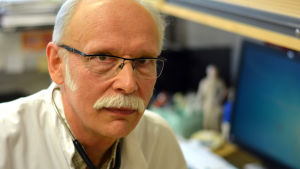Ingås ledande läkare Helge Heinonen. Porträttbild av Ingåläkaren Helge Heinonen i läkarrock och med stetoskop runt halsen.