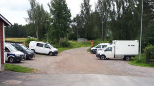 Polisen parkerade merparten av fordonen vid frivilliga brandkåren. Polisfordon på en grusad parkeringsplats.