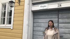 Under sommaren öppnar Niina Nyblom upp sitt hem för turister. Niina Nyblom står framför träporten till sitt gamla hus i Nådendal