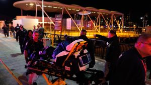 En av passagerarna i olyckshelikoptern tas om hand av ambulanspersonal. En av passagerarna i olyckshelikoptern tas om hand av ambulanspersonal.