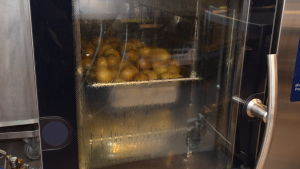 Potatisen blir mjuk i en ugn. Potatis värms upp i en ugn i Källhagens skolas kök i Virkby.