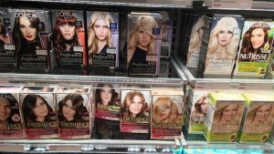 Yle Västnyland gjorde en snabb koll bland produkterna i en butik. Det står om åldergräns på de flesta förpackningar på utsidan. Den här bilden är inte tagen i samband med den kollen. En bild på burkar med hårfärg som står uppradade på hyllor. På burkarna finns människor med svallande hår och längst ner står runga burkar som är turkosa och svarta.