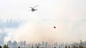 Släckningsarbetet i de svenska skogarna är enormt. Helikopter som släcker skogsbränder i Sverige.
