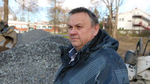 Närpes fortsätter hålla igång värme i de nedlagda skolorna, berättar tekniska direktören Edd Grahn. En medelålders man med kort mörkt hår står intill en grushög.