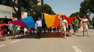 Pride-parad i Tirana Deltagare i Pridefestivalen i Tirana håller upp prideflagga