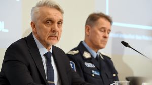Jari Liukku från Europol och polisöverdirektör Seppo Kolehmainen på dagens presskonferens. En man i kostym och en man i polisuniform sitter vid ett bord.