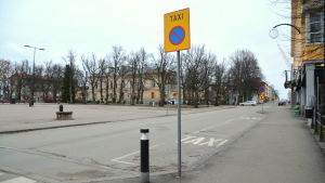 Taxistationen i Borgå revs i mitten på september. Nu håller taxibilarna till vid fyra taxistolpar. En taxistolpe vid sidan av en gata.