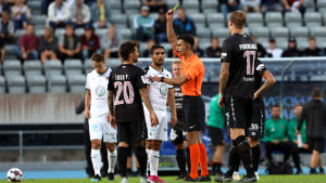 Spelarna har valt Mohammad Al-Emara till fotbollsligans bästa domare tre år i rad. Mohammad Al-Emara visar gult kort i en spelarklunga.
