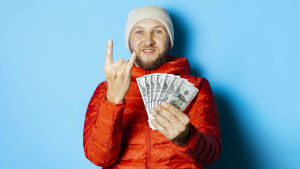 Yeaaahhh, ska lägga varenda slant på ... barnens sparkonto. Man med solfjäder av dollarsedlar i handen