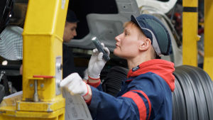 Autotyöläinen Tanja Leino sarjassa Tehtaan sankarit. Autotyöläinen Tanja Leino tehtaalla taskulampun kanssa.