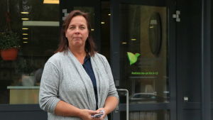 Cati Huhta på Sydvästra Finlands avfallshantering är glad över att så många har velat lämna in lump som de inte längre behöver. cati huhta i grå klädsel utanför sydvästra finlands avfallshanterings kontor