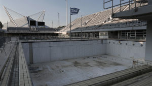 Simstadion var inte i aktivt bruk bara tio år efter OS i Aten. en tom simbassäng på en simstadion i aten. bassängen användes vid simhoppningstävlingarna under olympiska spelen i aten 2004