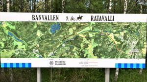 Den här kartbilden finns vid leden i Åminnefors. Den visar hur Banvallen löper från Karis via bruken i Pojo till Fiskars. En karta som med en bild tagen från luften visar hur den nya friluftsleden i Raseborg, Banvallen, löper från Karis via Billnäs och Åminnefors till Skuru och Fiskars bruk.