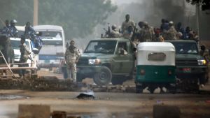 Sudanesiska säkerhetsstyrkor utanför militärhögkvarteret i Khartoum på måndagen då de försökte skingra protestlägret där. Sudanesiska säkerhetsstyrkor utanför militärhögkvarteret i Khartoum på måndagen då de försökte skingra protestlägret där.
