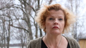 Enligt stadsdirektören Minna Nikander har man inte försökt dölja den ekonomiska situationen i staden.. En kvinna i 50-årsåldern med axellångt rödbrunthår. I bakgrunden syns träd.