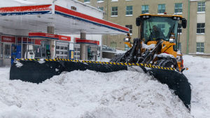 Det tar flera dagar att ploga bort all snö från gator och trottoarer i en stad. Traktor röjer snö på gård.