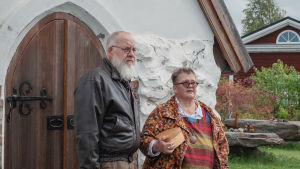 Mies ja nainen seivovat pienen kivikirkon oven edustalla.