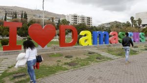 Syrier promenerar förbi en installation med texten  "I love Damascus"  i centrum av Syriens huvudstad Damaskus 22.2.2018.