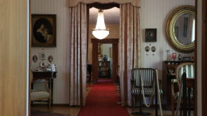 En lång korridor för besökarna genom matsalen och vardagsrummet in till Rafael Lönnströms arbetsrum. Lönnströms hemmuseum i Raumo.
