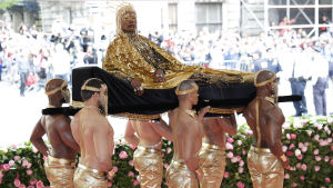 En av gästerna anländer storstilat till The Met Gala. Billy Porten anländer till välgörenhetsgalan buren av sex män i guldbyxor.