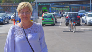 Stina Lindgård tycker det är en bra idé att samåka. Kvinna står och ler vid matbutik i Borgå.