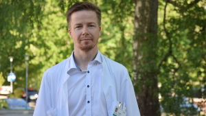 Överläkare Fredrik Forsström jobbar på avdelningen för inre medicin på Raseborgs sjukhus. En man (läkare) i vit läkarrock poserar utomhus. Ser rakt in i kameran. Sommar.