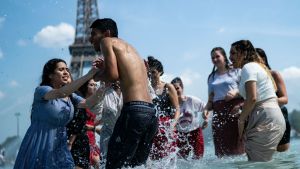 Människor svalkar sig i en en fontän vid Trocadero i Paris 25.6.2019 Personer som svalkar sig i en fontän i Paris.