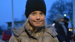 Alicia Sjöberg var där med sin mamma. En liten flicka står och ler i en park i skymningen.