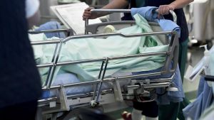 Intensivvårdplatserna borde räcka till, men brist på personal kan det bli om coronaviruset fortsätter spridas. En person skuffar en sjukhussäng på Jorv sjukhus i Esbo.