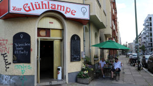 Kunderna vid baren ”Glödlampan” är framför allt lokala och stamgäster. En gata och baren Zur Glühlampe i Berlin