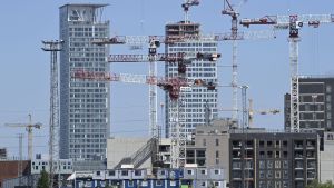 Djungeln av underleverantörer gör byggarbetplatserna svåra att övervaka gällande grå ekonomi. Många lyftkranar runt nya skyskrapor vid Fiskehamnen i juni 2020 i Helsingfors