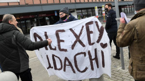 Många tog farväl av Navalnyj i Berlin. På lakanet står det "Alexej lycka till". Kvinna håller lakan med texten "Alexej lycka till " i Berlin.