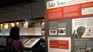Avdelningen för fake news är flitigt besökt på Newseum. Här en kvkinna frmaför bilden på Donald Trump.