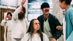 Hövding Bromden (Robert Kock) och McMurphy (Robin Svartström) flankerade av Martini (Tommi Eronen) och Scanlon (Amira Khalifa). I bakrunden Mikko Penttilä som Cheswick och Tiia Louste som Professor Harding. Foto från Yksi lensi yli käenpesän på Sveaborgs sommarteater.