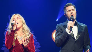 Krista Siegfrids och Peter Jöback i konserten Decemberkväll. Krista Siegfrids och Peter Jöback sjunger med ögonen slutna.