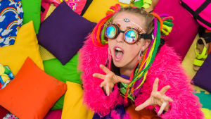 Vicky O'Neon poserar i färgranna kläder med färgade brillor.