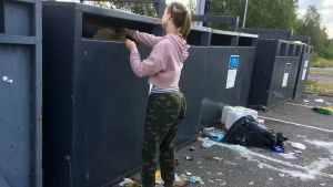 Det är inte lätt att ta sig fram till avfallskärlet då vi besöker platsen. En kvinna sätter in avfall i en behållare vid en sorteringsstation.