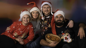 Malin, Lisa, Staffan och Emil julmyser med barnen. BUU-klubbens programledare poserar i juliga kläder i en soffa