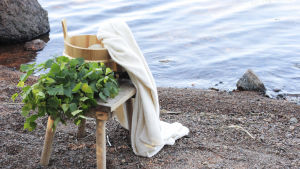 Bastubadet kan bli en nationell kulturangelägenhet - mera än någonsin, alltså Bastutillbehör på strand vid vattnet.