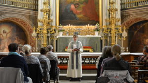 En präst talar framför altaret i Åbo domkyrka där en kvällsmässa ordnades för att minnas offren i fredagens attack i Åbo.