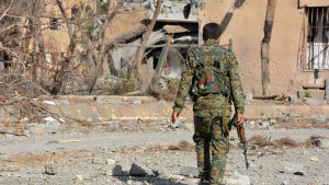 En YPG-krigare i terrorgruppen IS tidigare huvudstad Raqqa. En YPG-krigare går längs med en förstörd gata i terrorgruppen IS tidigare syriska huvudstad Raqqa.