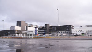 Ingången till logistikcentralen går via den takbelagda gångbron. Själva byggnaden fortsätter flera hundra meter mot höger, ut ur bilden. Stor svartgrå byggnad.