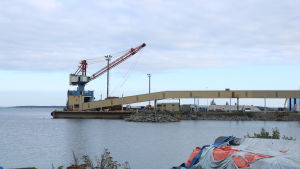 Verksamheten i hamnen på Björnö har ökat i och med nya aktörer. En kran vid en kaj i Kristinestad. Framför kranen går en transportlinje.