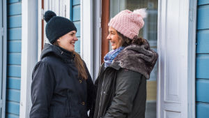 Ida Stepanow och Ronja Roms skulle vilja göra skolbesök. Två glada unga kvinnor iklädda mössa tittar på varandra