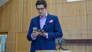Pappa Peter Fallström riggade upp telefonerna. Pappan står och petar på telefonen och försöker få dopet filmat.