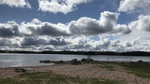 Så här ser stranden ut idag. Man kan fortfarande se två metallöglor som bryggan brukade sitta fast i. En strand en molnig vårdag.