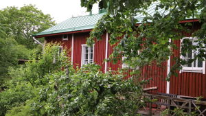 Här hittar man många idylliska små hus. Ett rött trähus med vita knutar i Raunistula.