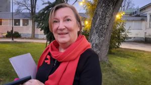 Kaarina Tynkkynen går i pension i början av nästa år från sitt jobb inom missbrukarvården i Hangö. Hon tycker vården fungerar bra i dag, men är orolig för vad vårdreformen innebär för missbrukarvården. Kvinna utomhus vid julgran
