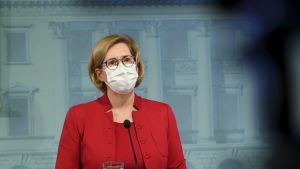 Regeringen tar över frågan om ökad sysselsättning bland äldre arbetstagare. Arbetsminister Tuula Haatainen utlovar ett beslut före utgången av 2020. Arbetsminister Tuula Haatainen i röd kostym och ljust munskydd står bakom en talarstol i Helsingfors den 19 november.